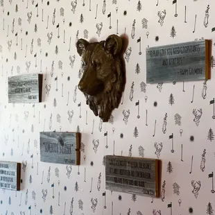 a wall covered with plaques and a bear head