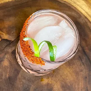 a drink with ice and a lime garnish