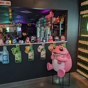 a one shot sign and a pink pig in front of a bar