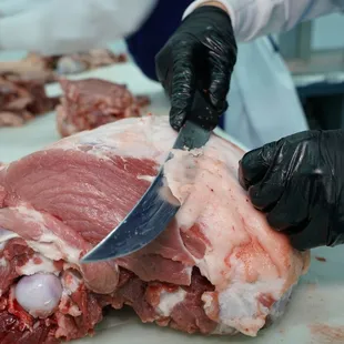 a person cutting a piece of meat