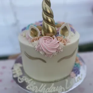 a birthday cake with a unicorn horn on top