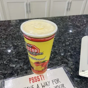 a smoothie and a sign on a counter