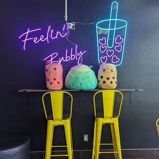 two yellow chairs and a neon sign