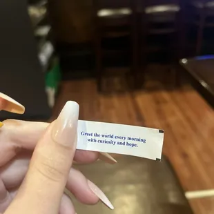 a person holding a piece of paper with a message on it