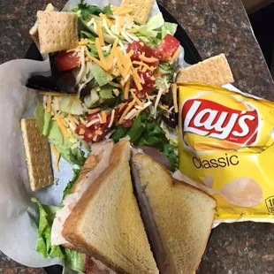 Triple Decker Club with a side salad.
