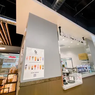 the inside of a restaurant with a counter and a display case