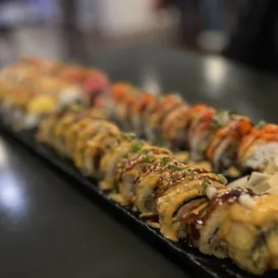 a long sushi roll on a black plate