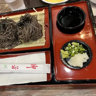 a plate of noodles, broccoli, and a bowl of soup
