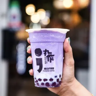 a hand holding a cup of bubble tea