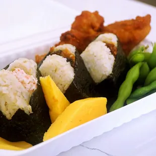 Bento Set w/3 Onigilly: 3 Onigilly w/ chicken karaage (fried chicken), tamagoyaki (omelette), edamame &amp; takuan (pickled radish) ($14.95).