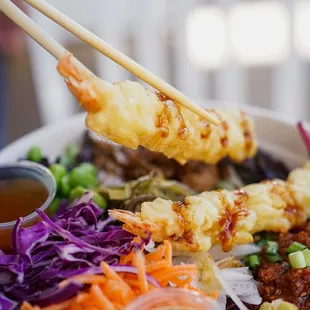 a bowl of food with chopsticks