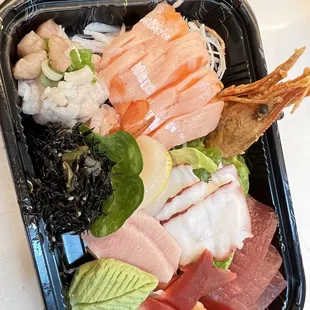 a tray of sushi and other foods