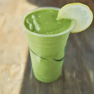 a green smoothie with a slice of lemon
