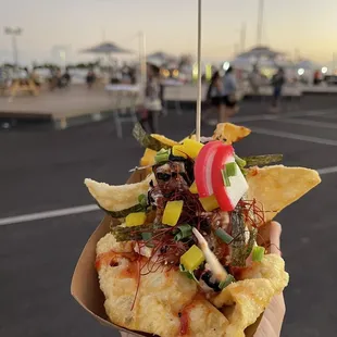 a hand holding a nacho