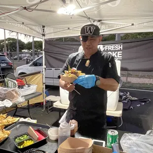 a man standing in front of a table of food