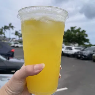 a hand holding a cup of juice