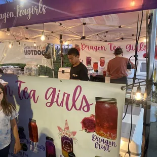 a woman standing in front of a tea girl&apos;s tent