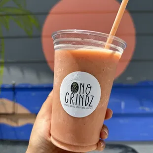 a hand holding a cup of smoothie