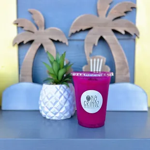 a pink cup with a straw and a pineapple