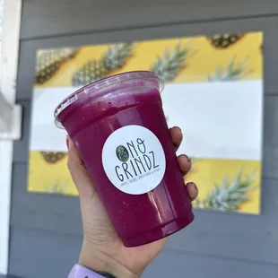 a hand holding a purple smoothie