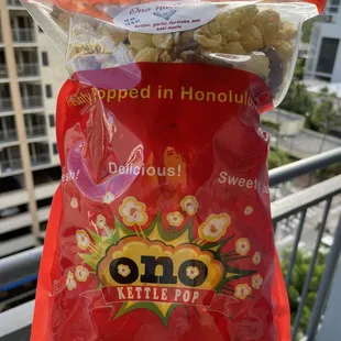 a hand holding a bag of popcorn