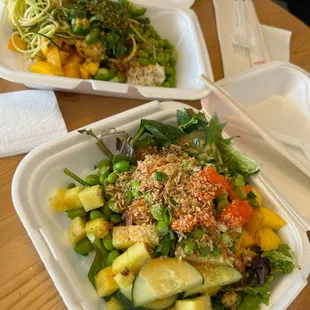 two take out containers of food on a table