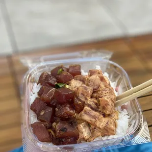 a hand holding a plastic container of food