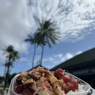 a hand holding a container of food
