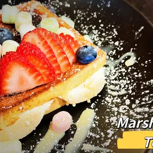 a plate of french toast topped with strawberries and blueberries