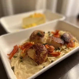 a plate of pasta with scallops and vegetables