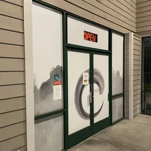 a storefront with a clock on the door