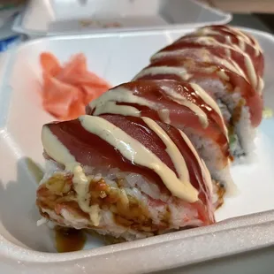 a sushi roll in a styrofoam container
