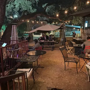 people sitting at tables under umbrellas