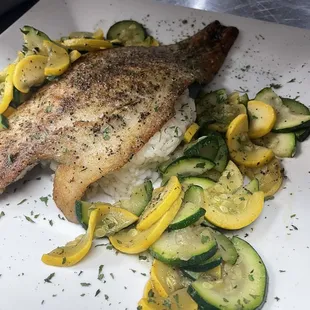 Lemon herb redfish Grilled redfished seasoned and topped with capers butter served over lemon dill pilaf with steamed veggies