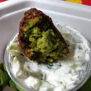 Inside a warm, delicious falafel with a side of fresh tzatziki.