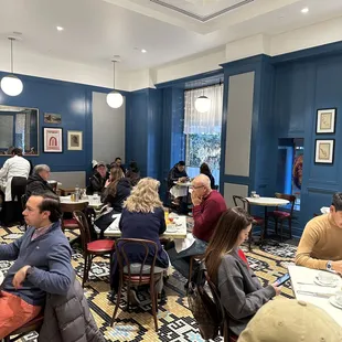 a group of people sitting at tables in a restaurant
