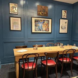 a dining room with a long table and red chairs