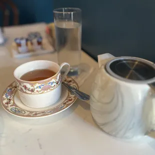 a cup of tea and a teapot on a table
