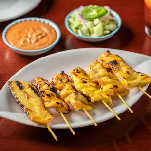 grilled chicken skewers on a white plate