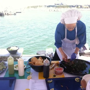 Lady making yummy rock fish and black cod sample tacos