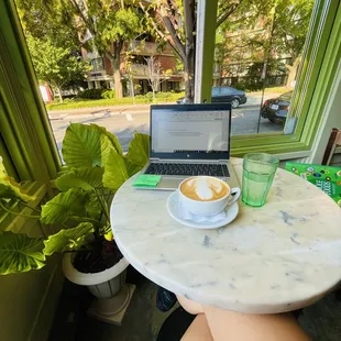 a cup of coffee and a laptop on a table
