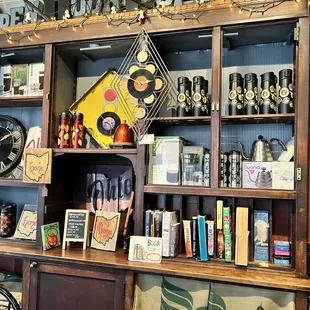 Bookshelf of books and games to borrow as well as merchandise for purchase