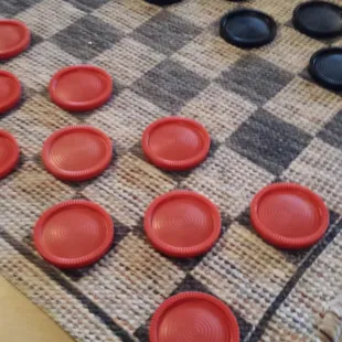 Oversized checkers pieces on table.