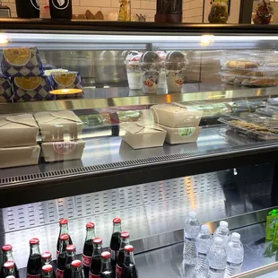 a display case filled with drinks and pastries
