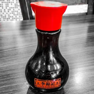 a black vase with a red lid