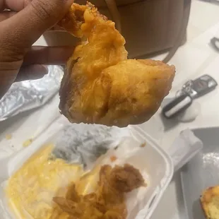 ows a hand holding a piece of food