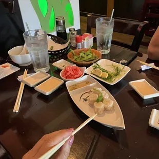 a table with plates of food and chopsticks