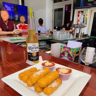 a plate of corn dogs and a bottle of beer