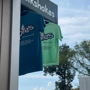 two t - shirts hanging on a pole