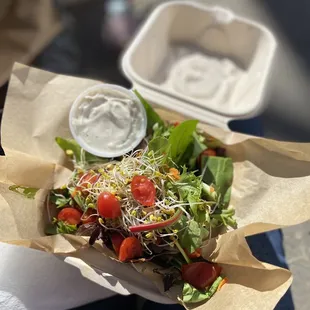 a person holding a salad in a paper bag